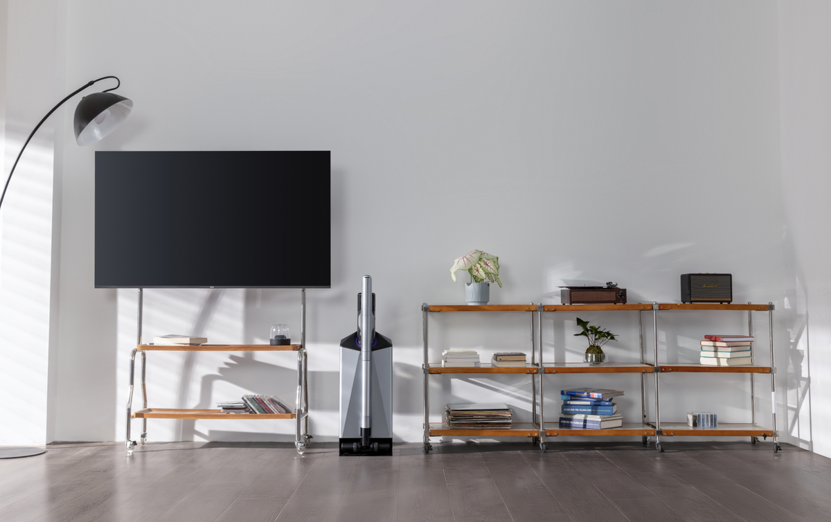 Narwal V50 Cube station between a TV and shelving in a bright living room